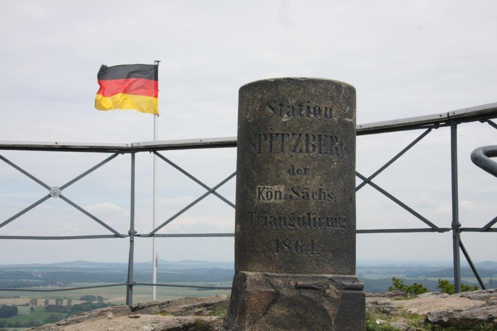 Triangulationssäule und Fahnenmast mit deutscher Flagge im Hintergrund